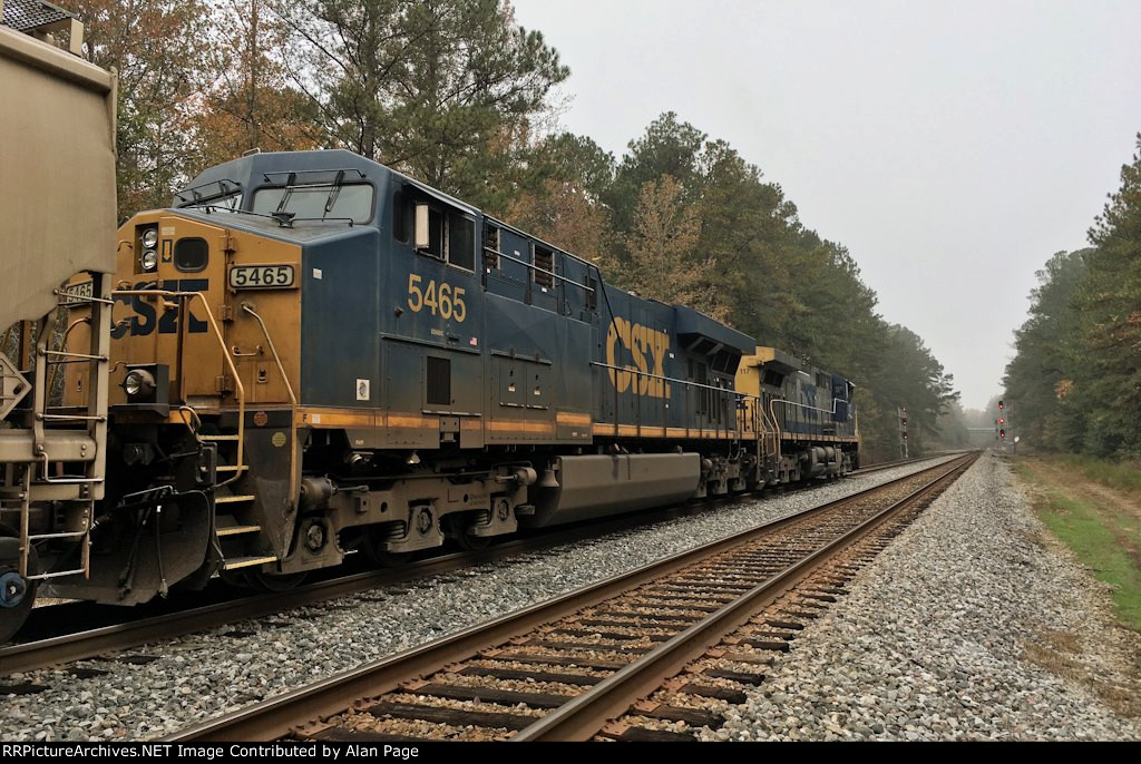 CSX 5465 and 117 wait for green with a line of covered hoppers at the N.E. Aberdeen signals